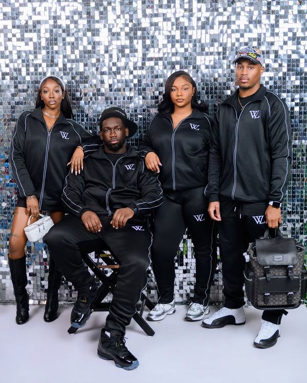 Four people wearing matching black outfits with a logo against a silver mosaic background